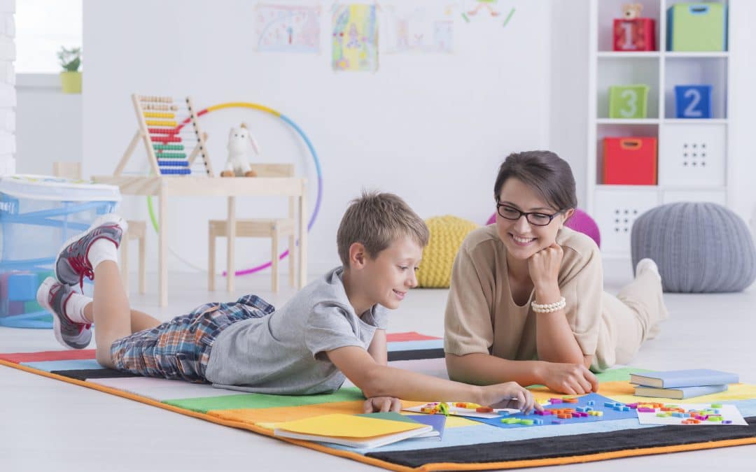 A therapist and a child smiling together during a play therapy session